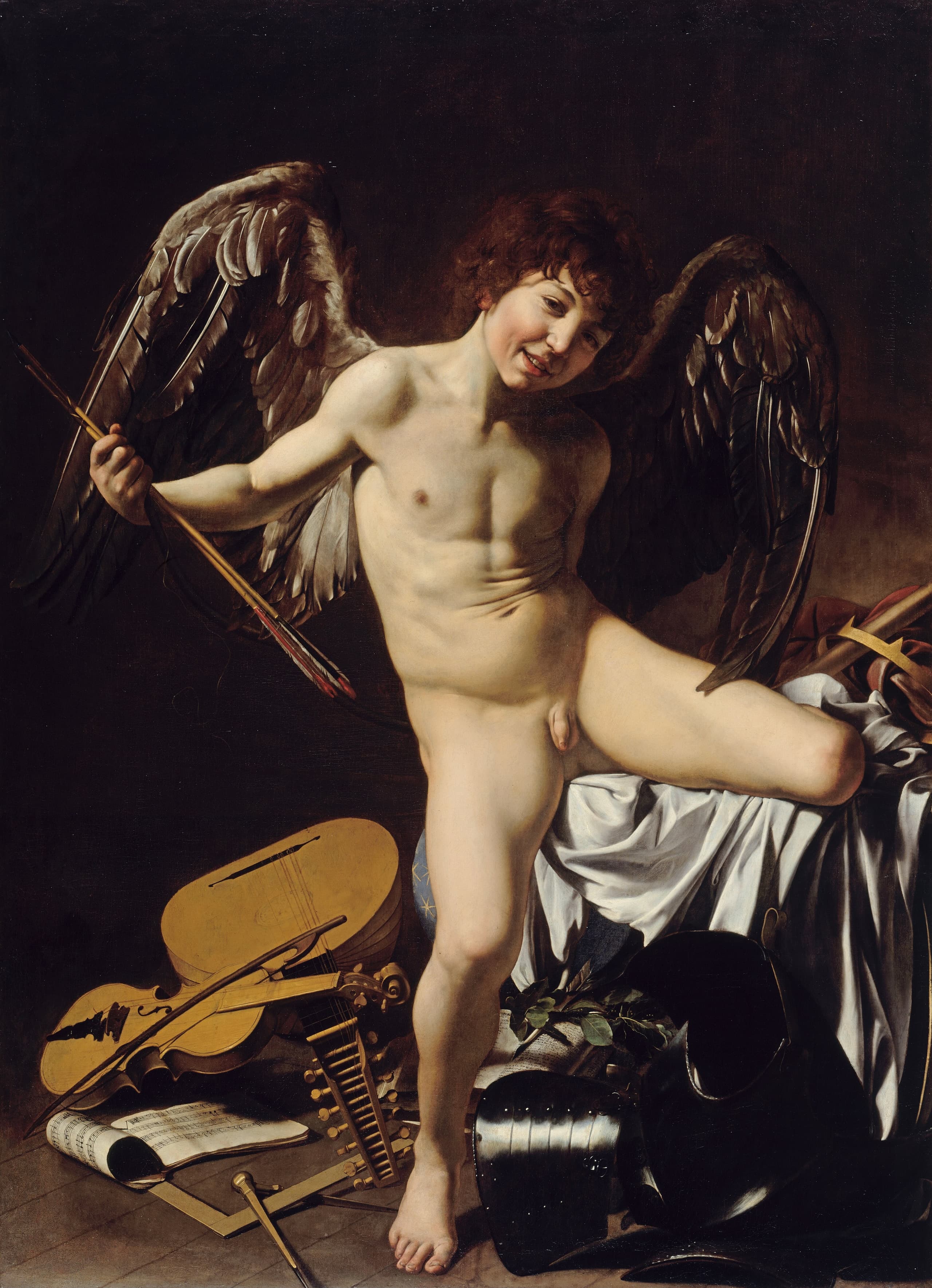 A nude adolescent boy with dark wings stands with legs crossed and arms spread, grinning, above a heap of objects including musical instruments, armour, a manuscript, and a crown.