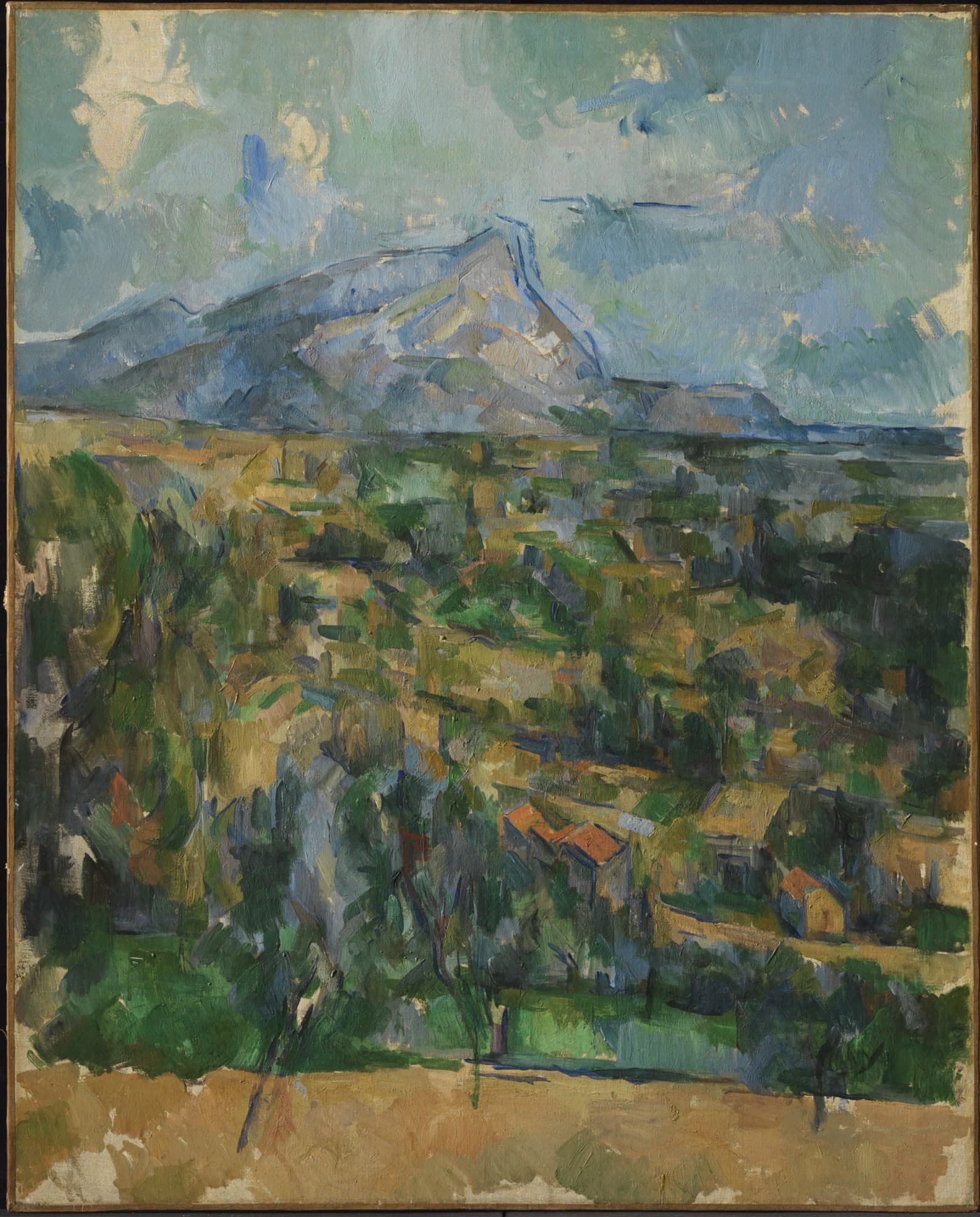 A pale limestone mountain ridge rising against a blue sky, with green and ochre fields and dark pines in the foreground, all rendered in distinct patches of colour without blended edges.