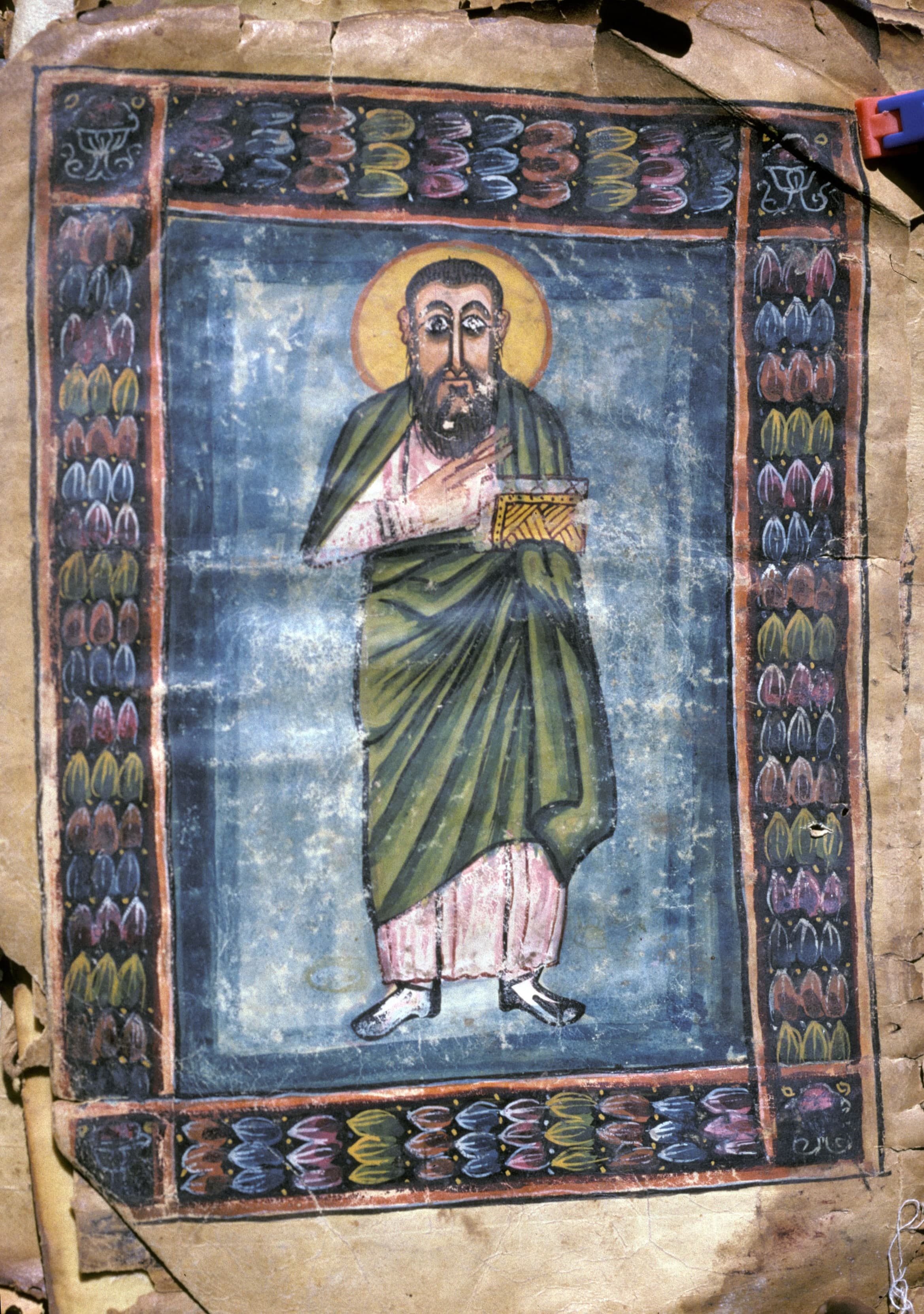 An open manuscript page with text in Geʽez script and a painted arcade of columns and arches framing a grid of numbers and references.