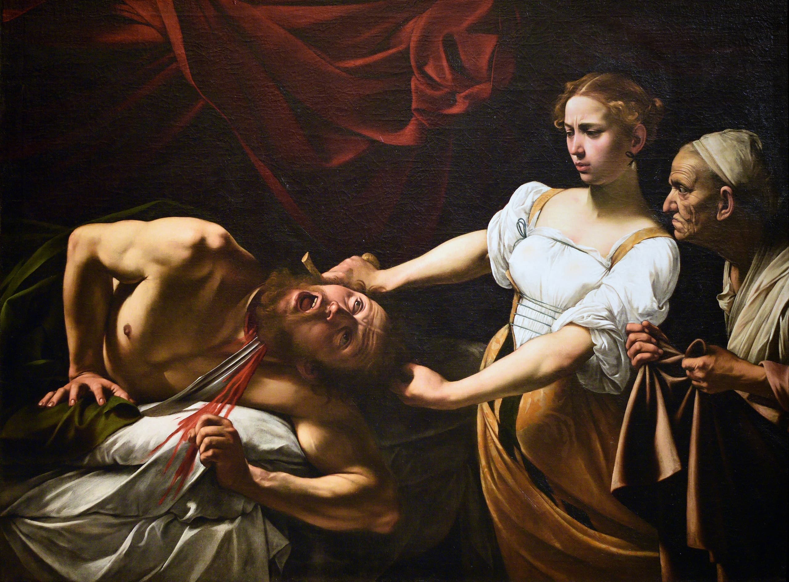 In a darkened tent, a woman steadies a sword as she cuts the neck of a man writhing on white bedding; an older woman leans in from the right with a cloth. Hard light strikes their arms and faces.