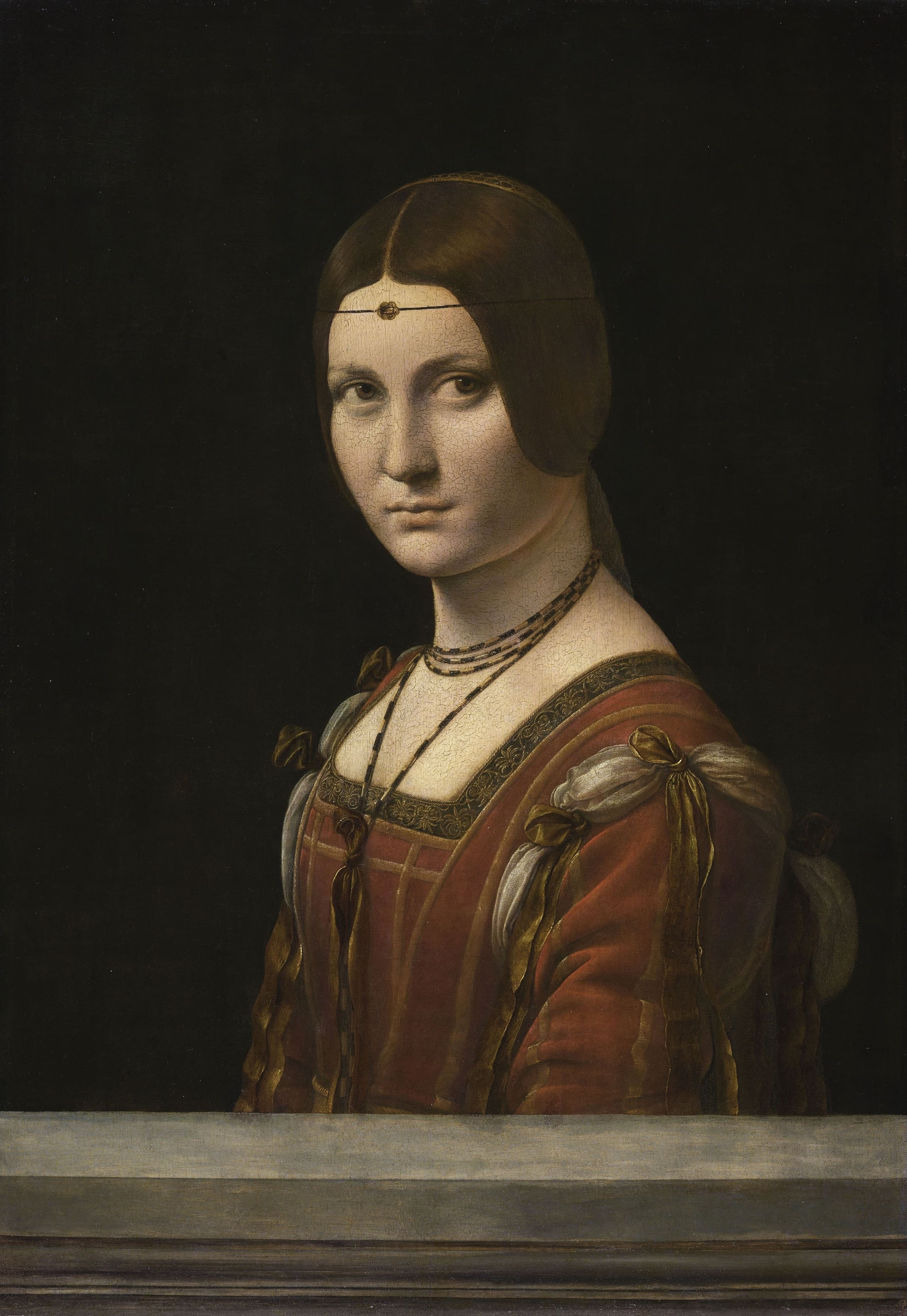 A painted portrait of a woman on a wooden panel, shown at close range against a dark ground, her face turned toward the viewer in the quiet format of a High Renaissance likeness.