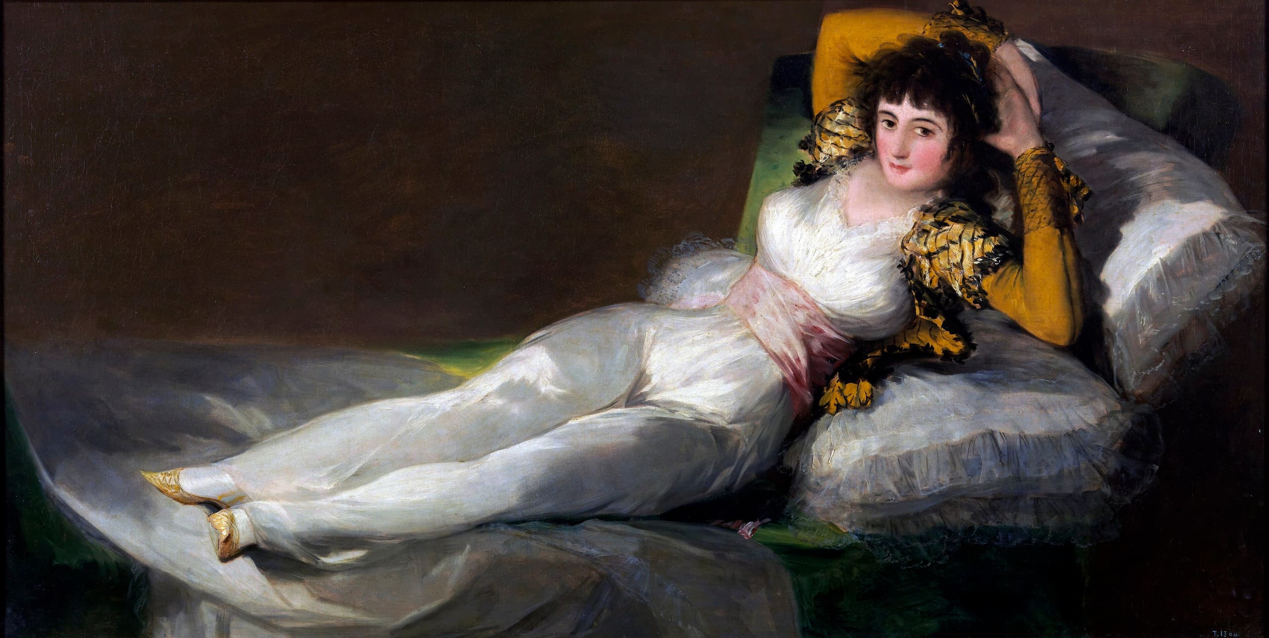 A woman reclines on green cushions, propped on her left elbow, wearing a white jacket with gold trim and a white skirt. She gazes directly at the viewer.