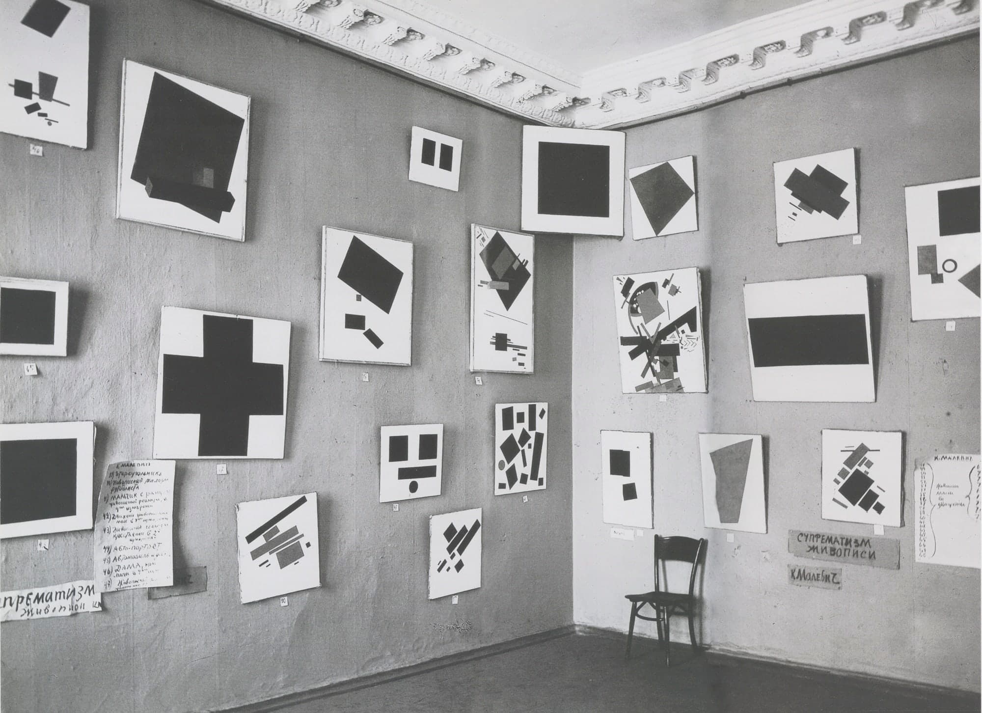 A black quadrilateral, nearly square, painted on a white canvas. The black surface is crazed with fine cracks. The white border is uneven in width on all sides.