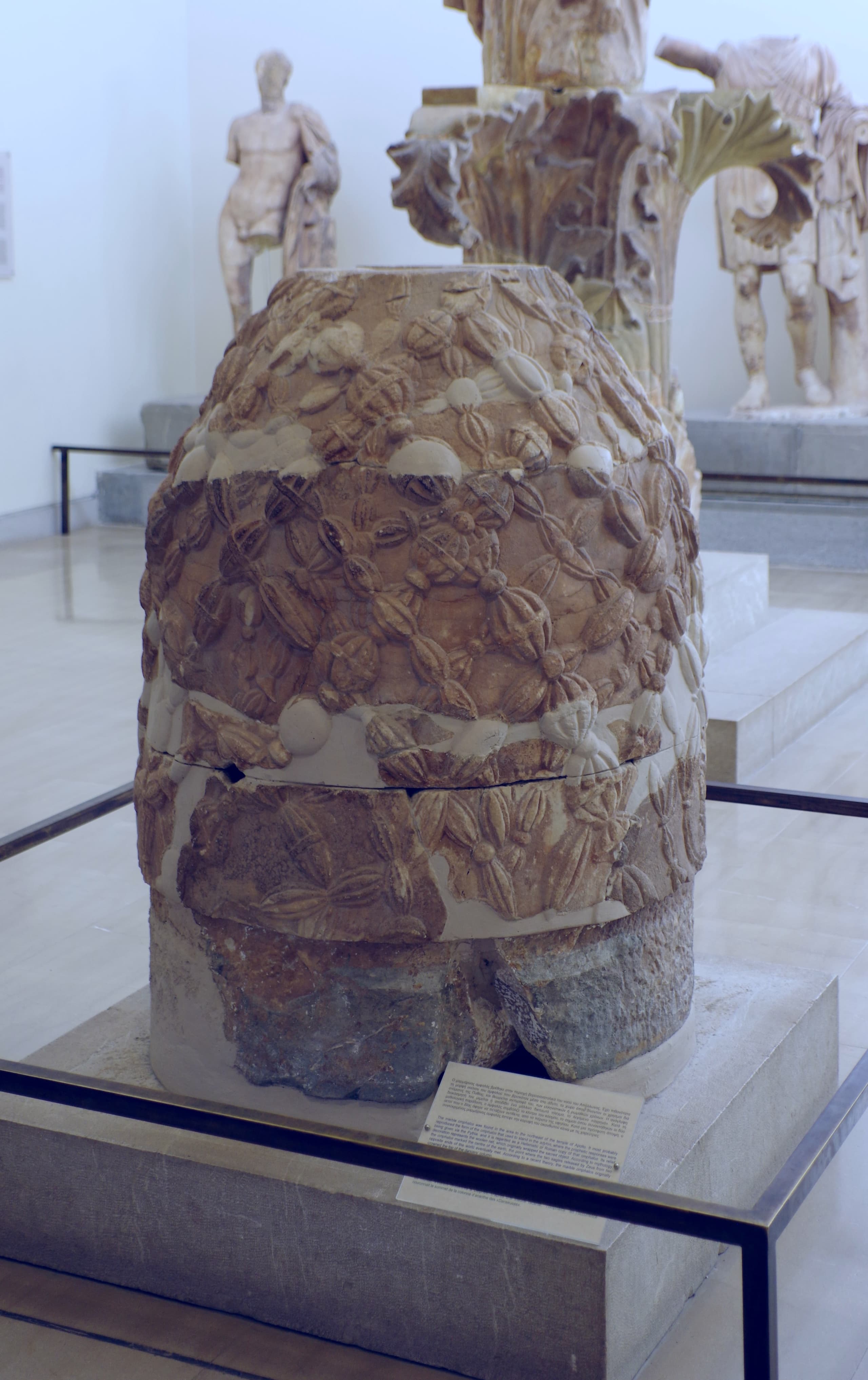 A rounded, dome-shaped stone standing on the ground, its worked surface covered in a dense raised pattern of interlacing bands, tapering slightly towards the top.