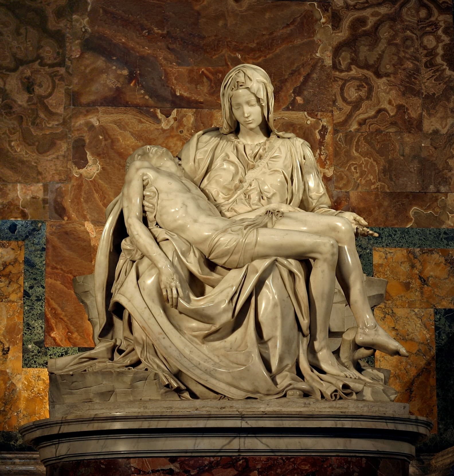 A polished marble pair: a seated woman in heavy folds holds a lifeless adult male across her lap, his arm falling free, her face smooth and young above his.