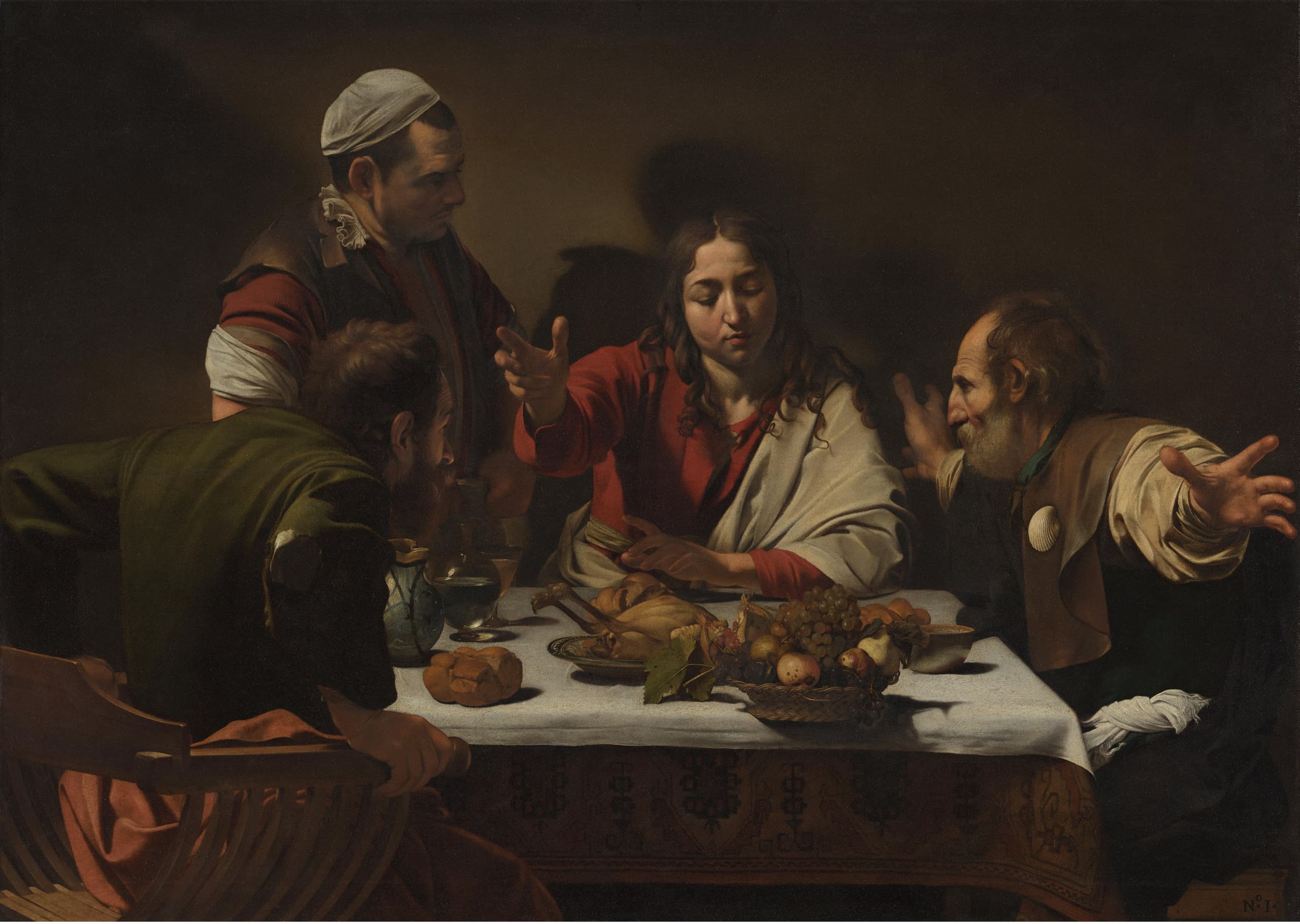 A lit table fills the lower half of a dark canvas. A central figure raises a hand over bread while two companions react sharply; a standing man looks on. A fruit basket sits at the near edge.