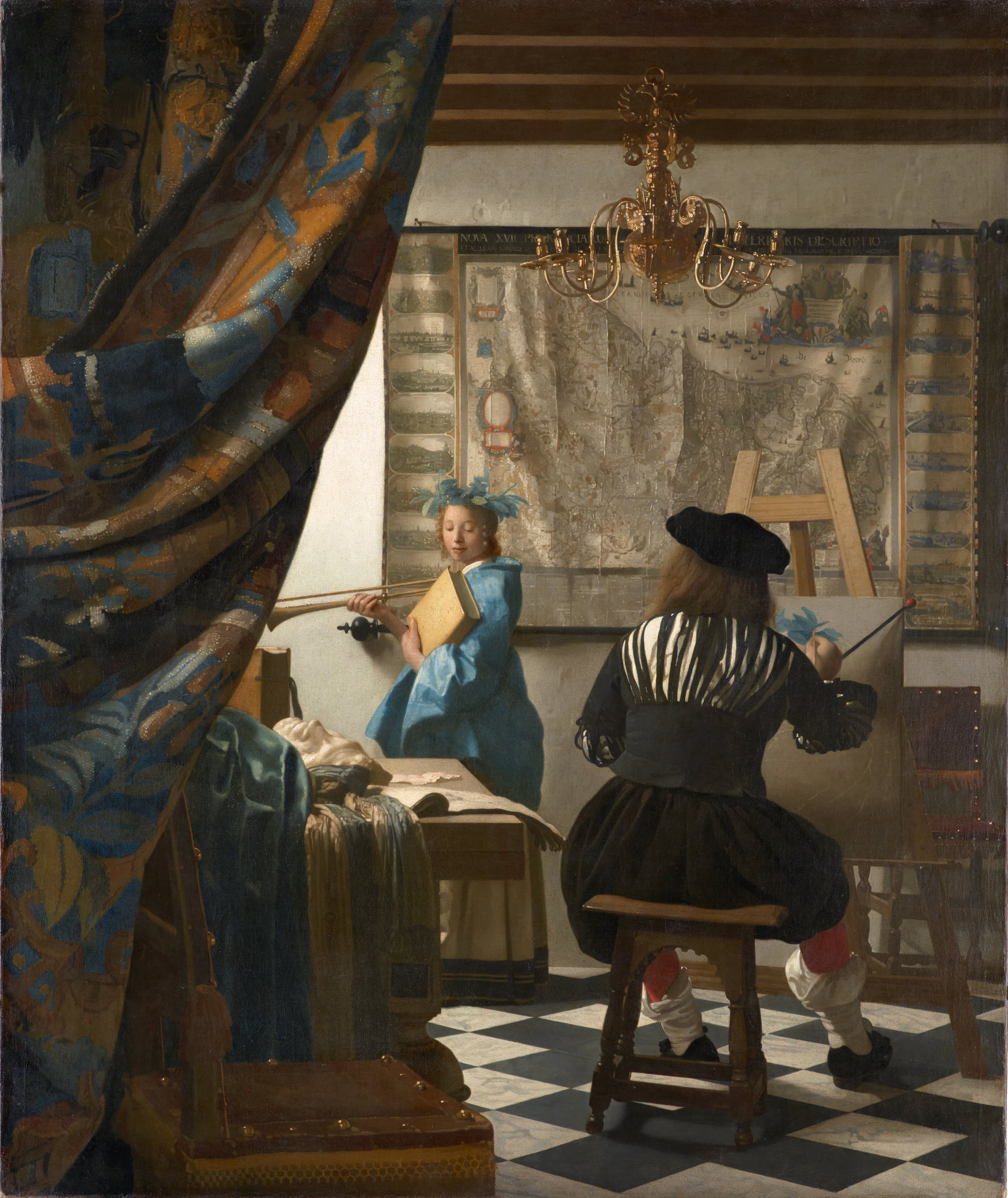 A curtain opens onto a sunlit studio. A painter sits with his back turned at an easel; a young woman in blue stands nearer the light beneath a large wall map, holding a book and trumpet. A chandelier hangs above a tiled floor.