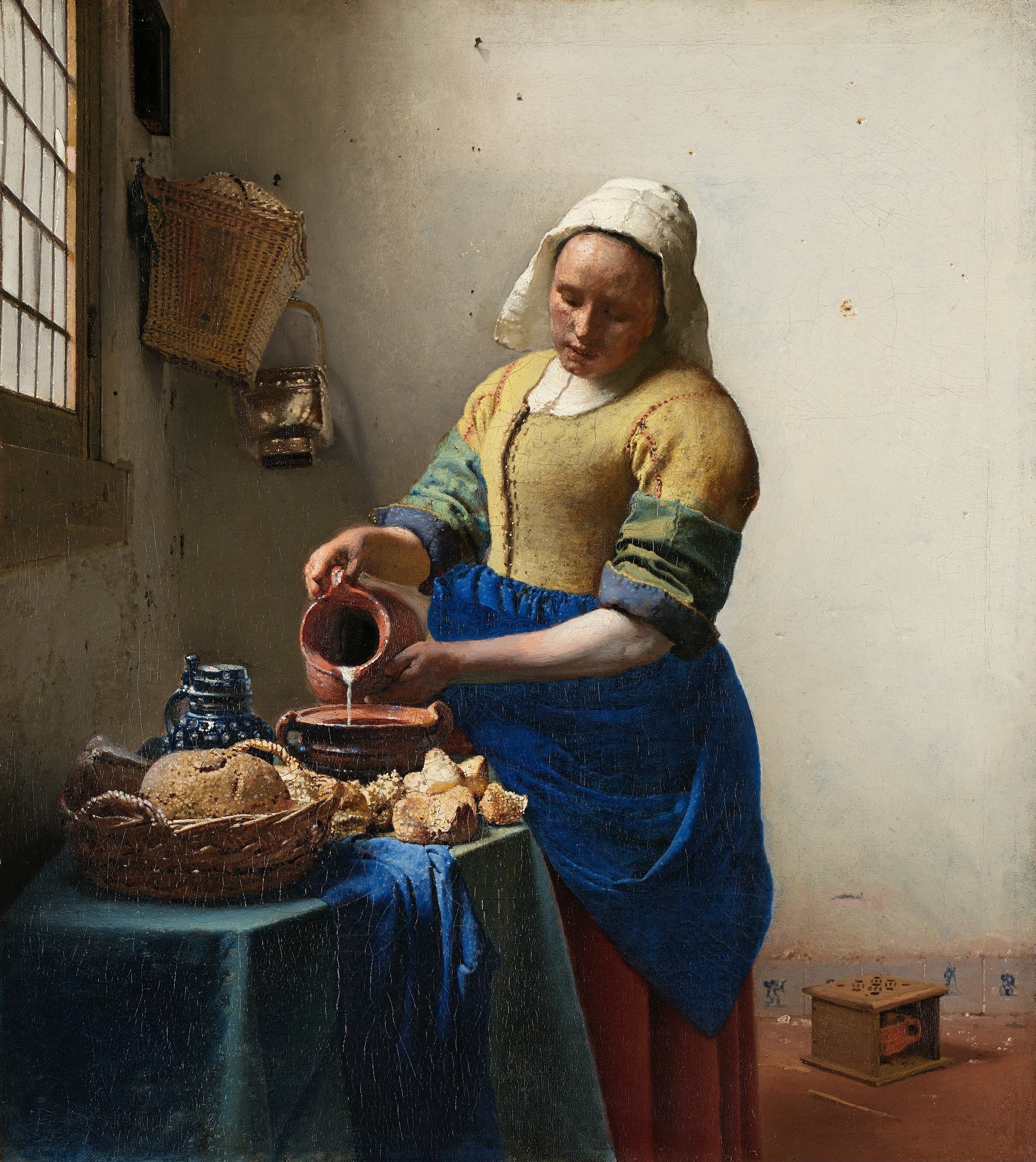 A domestic kitchen maid in work dress stands at a table in a plain interior, her attention fixed on a vessel as she handles milk, filling most of a small vertical canvas.