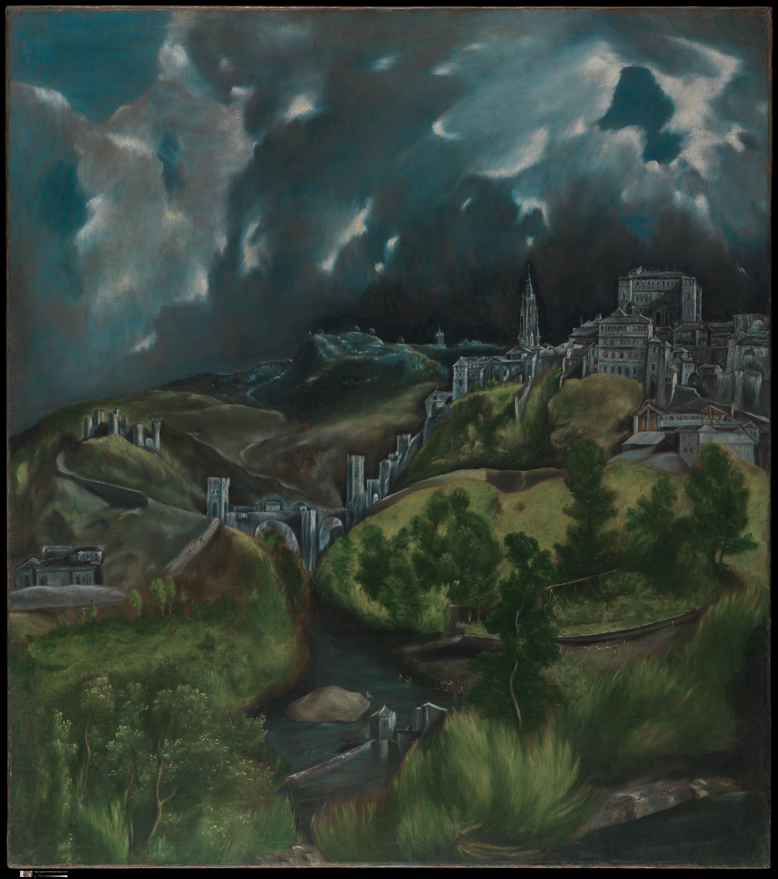 A hilltop city of pale stone walls, packed roofs and tall towers, rising above green folded slopes and a river crossed by a bridge, beneath a large dark grey-blue sky torn by lighter streaks.