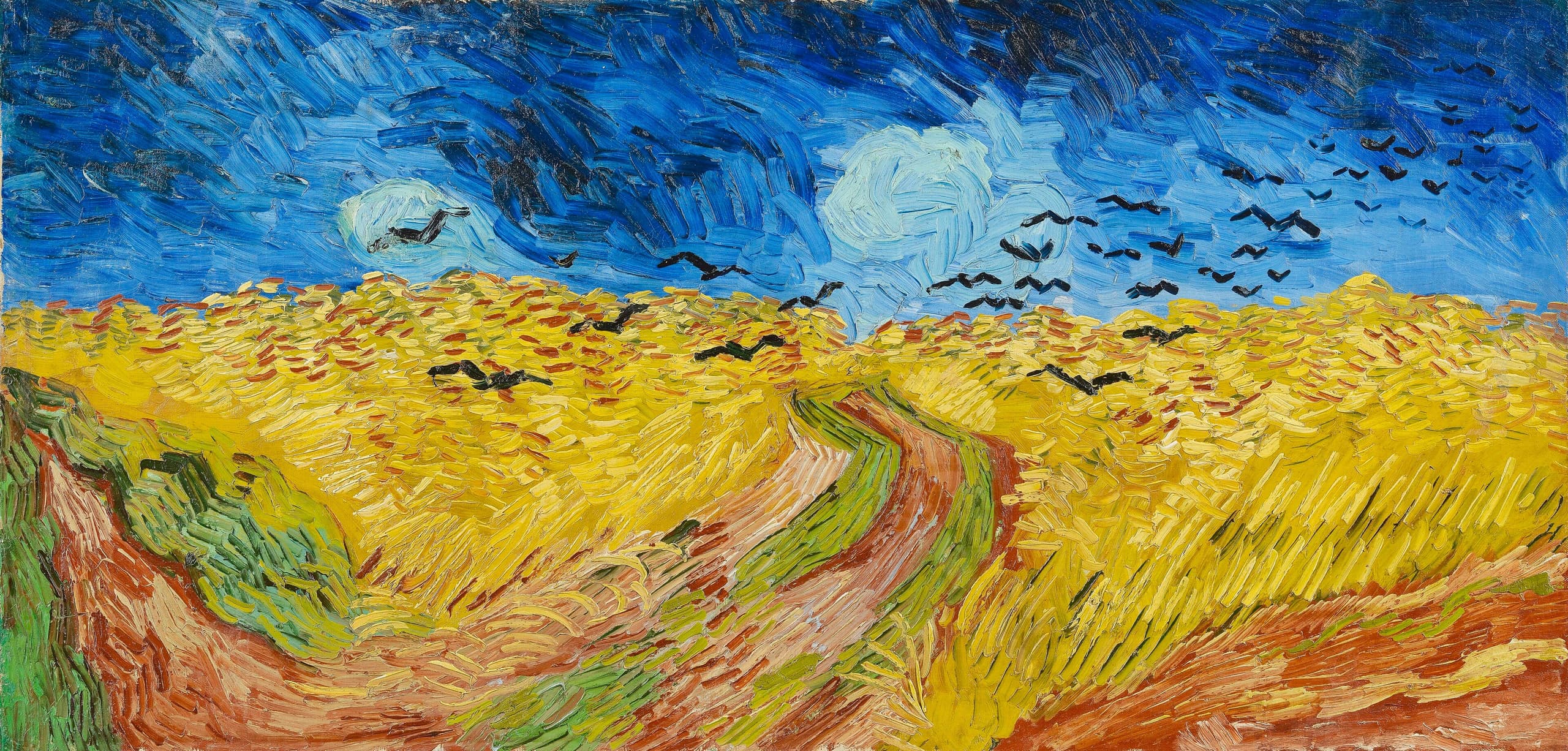 A wide wheat field in yellow and green under a dark blue and grey sky. Three dirt paths fork through the foreground. Black birds scatter across the upper portion.