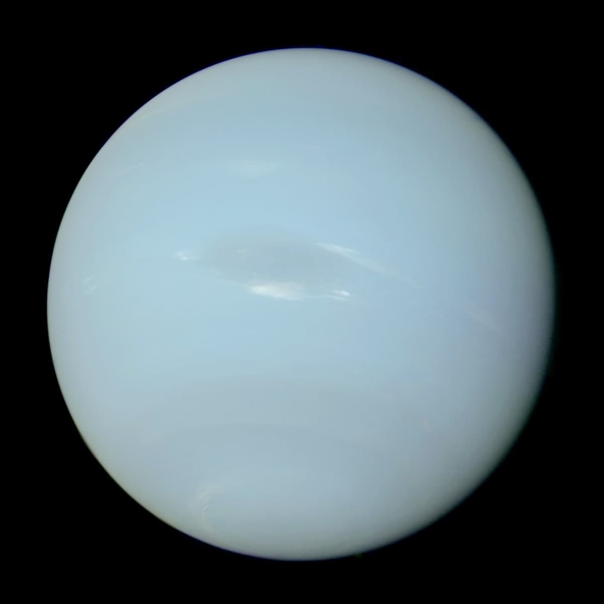 Neptune as photographed by Voyager 2, showing a blue sphere with faint banding and a large dark oval storm in the southern hemisphere.