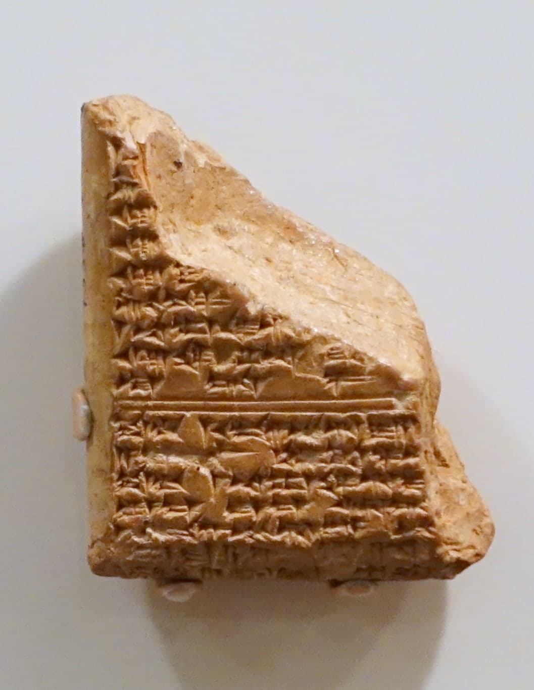 Clay tablets densely inscribed with cuneiform script, the wedge-shaped marks pressed into the surface in horizontal lines.