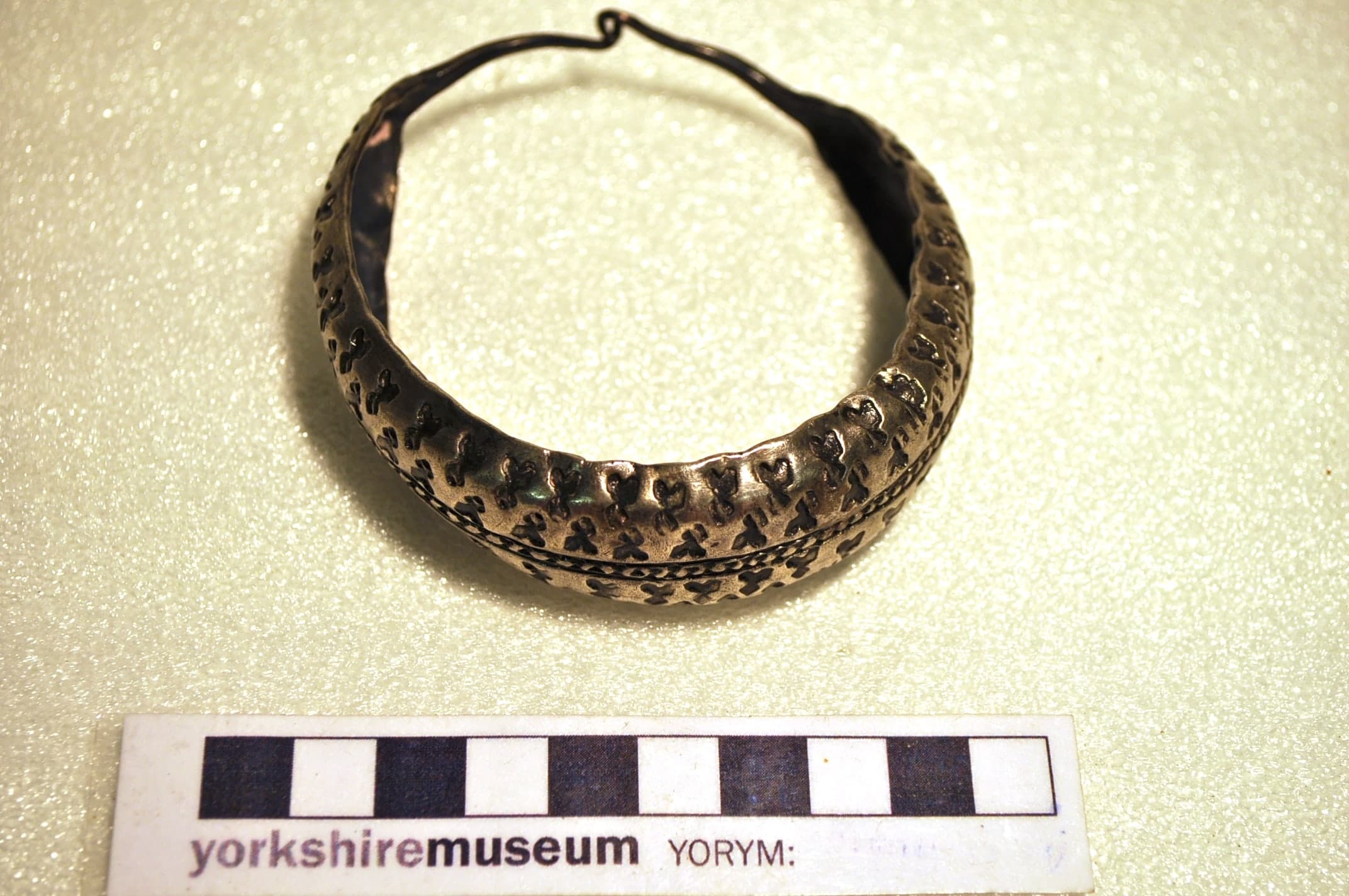 Silver jewellery, cut silver fragments and coins from a hoard, arranged as a mixed early-tenth-century deposit rather than a single matching set.
