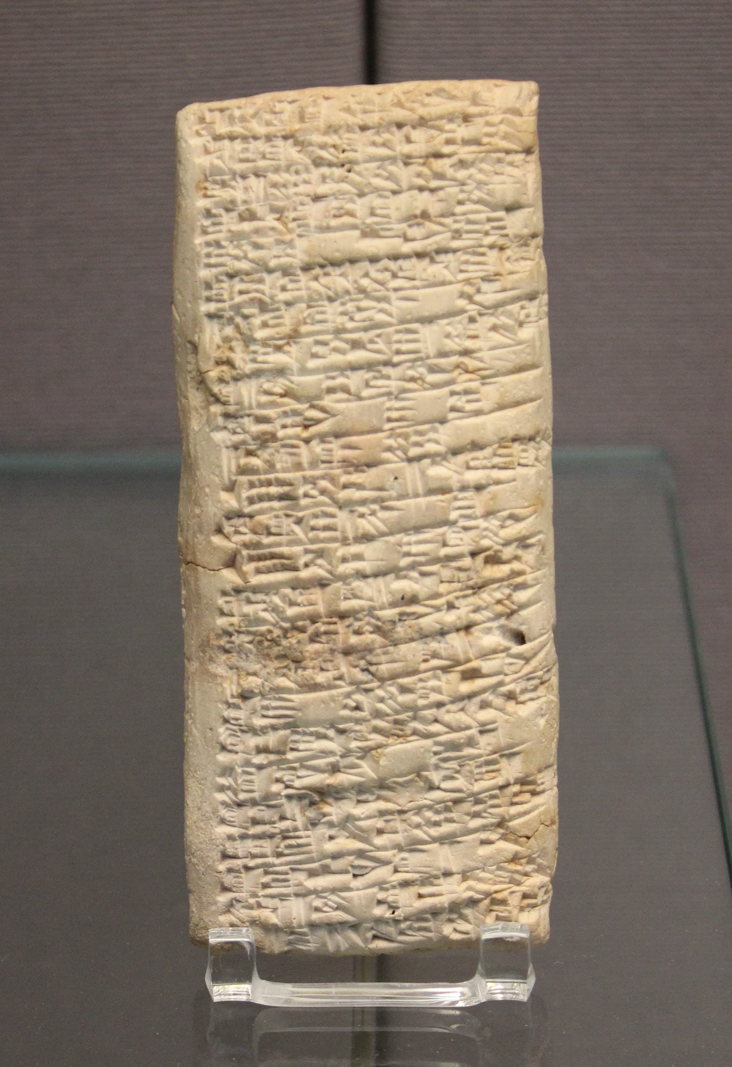 A small rectangular clay tablet covered in dense rows of cuneiform wedge marks, shown against a plain background.