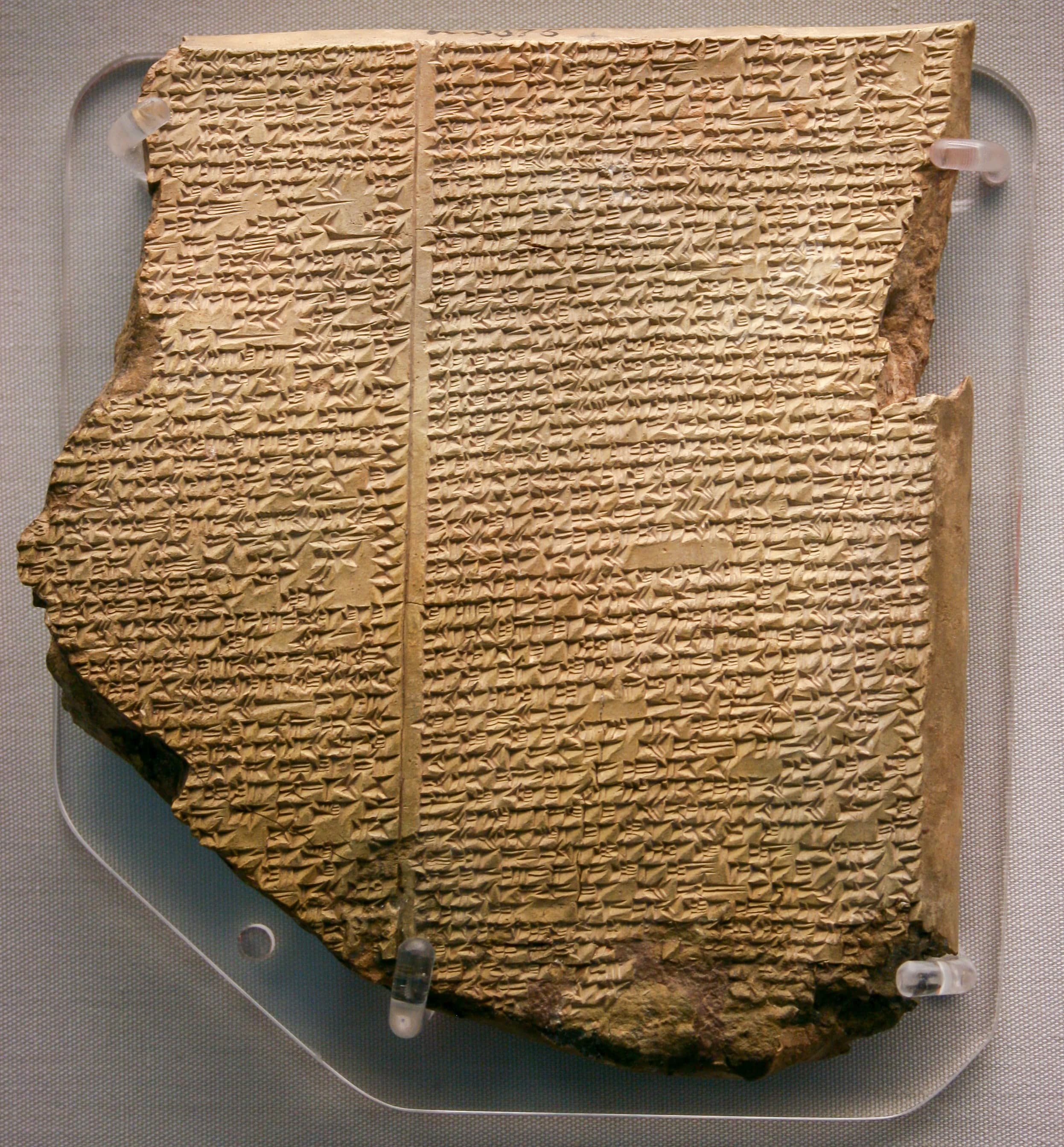 A fragment of clay tablet inscribed with dense rows of cuneiform script, the wedge-shaped characters pressed into the surface in horizontal lines.