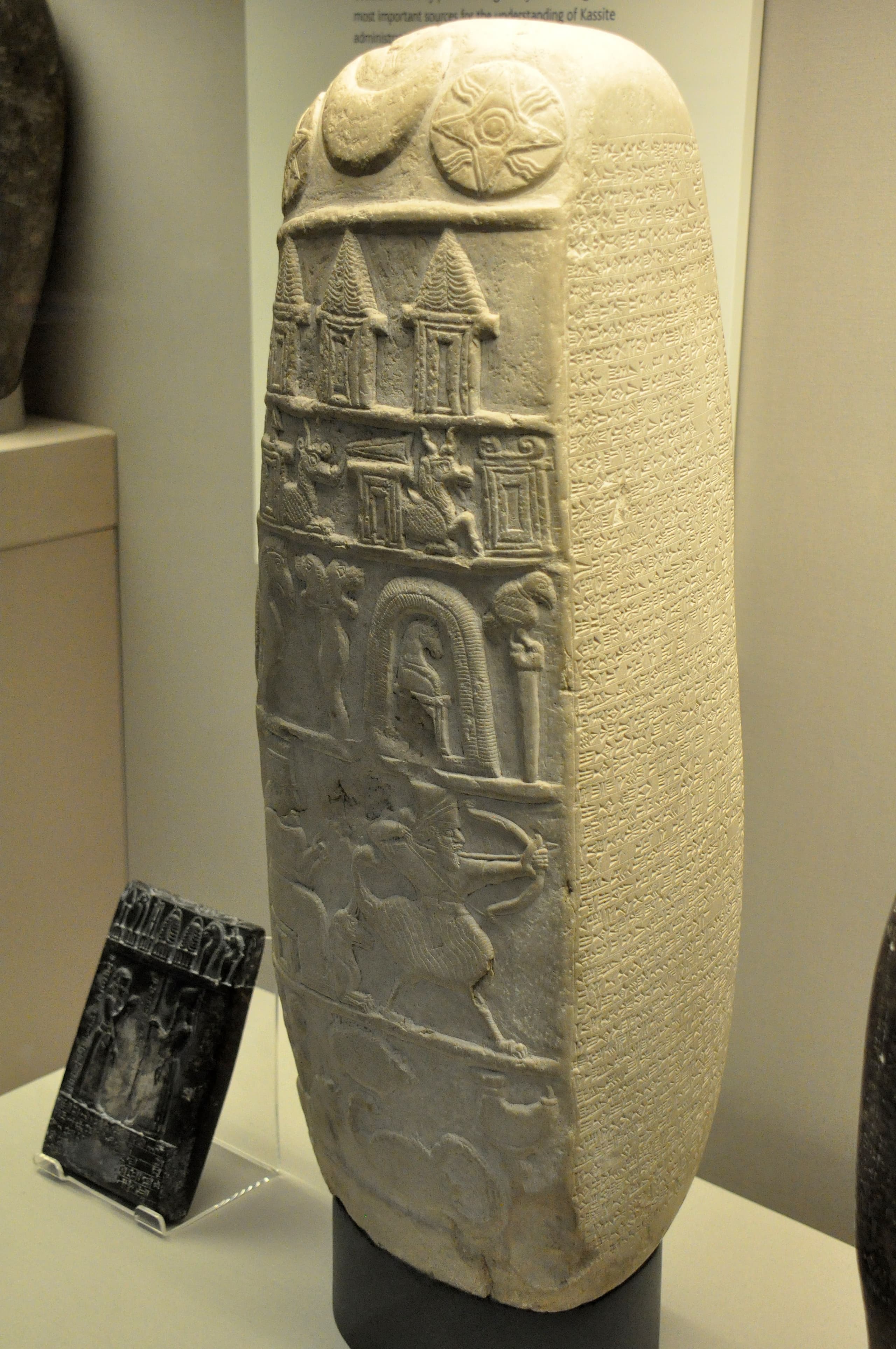 A four-sided limestone stele, a kudurru, with surfaces given over to incised cuneiform and the compact proportions of a memorial narû.