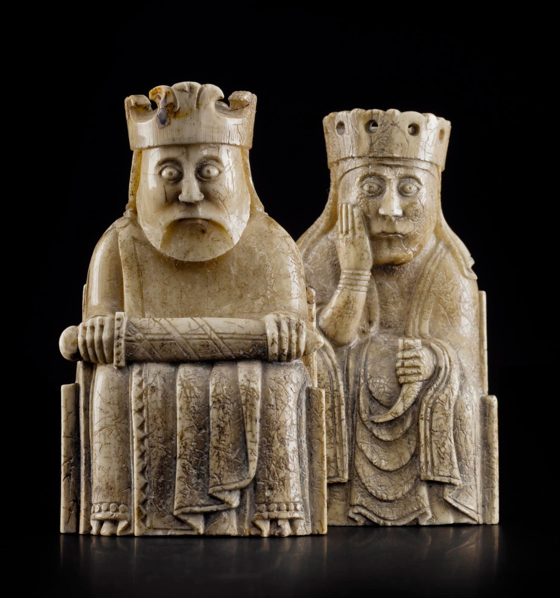 Carved walrus ivory chess pieces showing seated kings and queens, standing bishops with croziers, mounted knights, and warders holding shields, with detailed facial expressions ranging from solemn to weary.