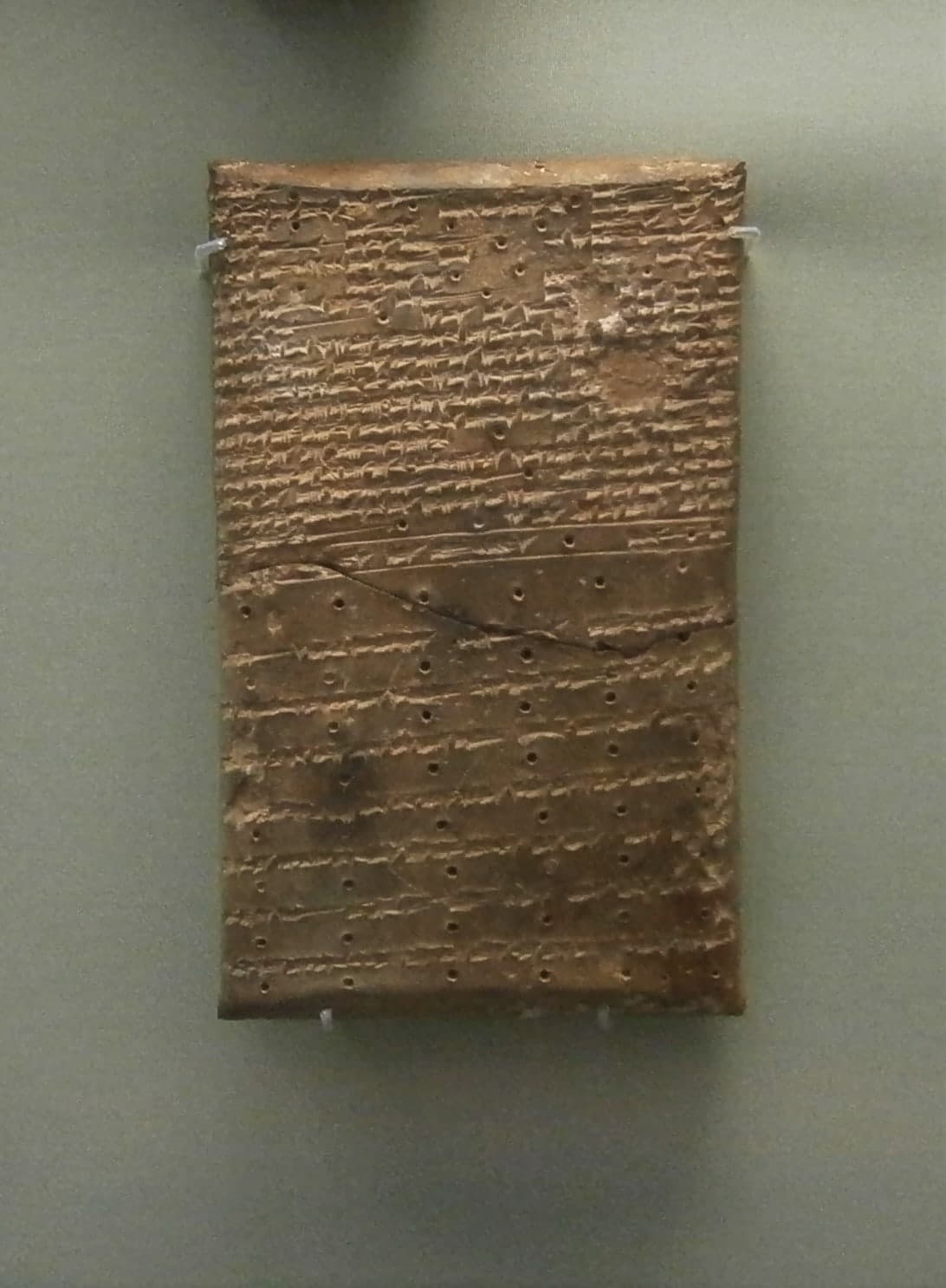 A group of pale brown clay tablets and fragments densely impressed with cuneiform script, some corners broken, shown as study objects from an ancient Mesopotamian archive.