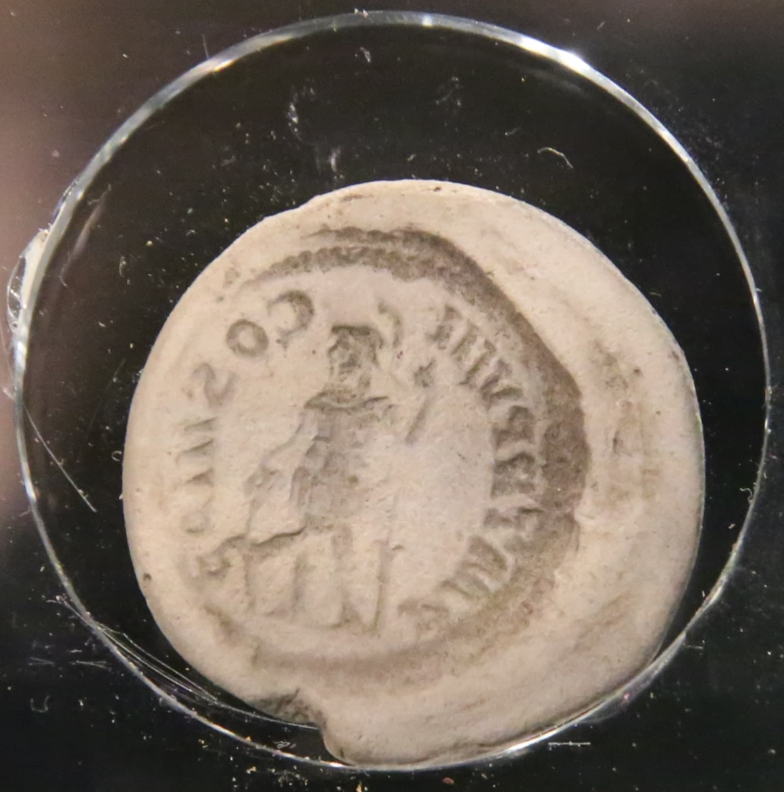 Small pale clay blocks and fragments with circular recesses, the negative impressions of coin faces, shown as a scattered group of modest archaeological moulds.