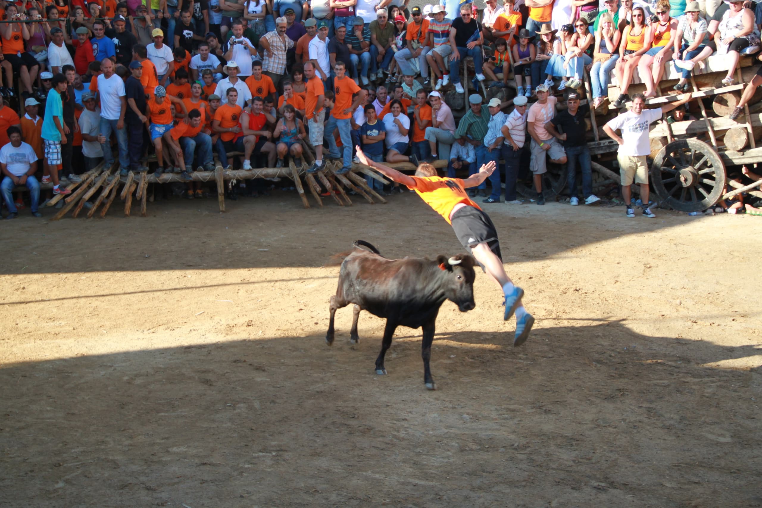 A bronze figurine of an acrobat arched in mid-air above a bull, arms extended toward the animal's horns, legs trailing behind in a somersault position.