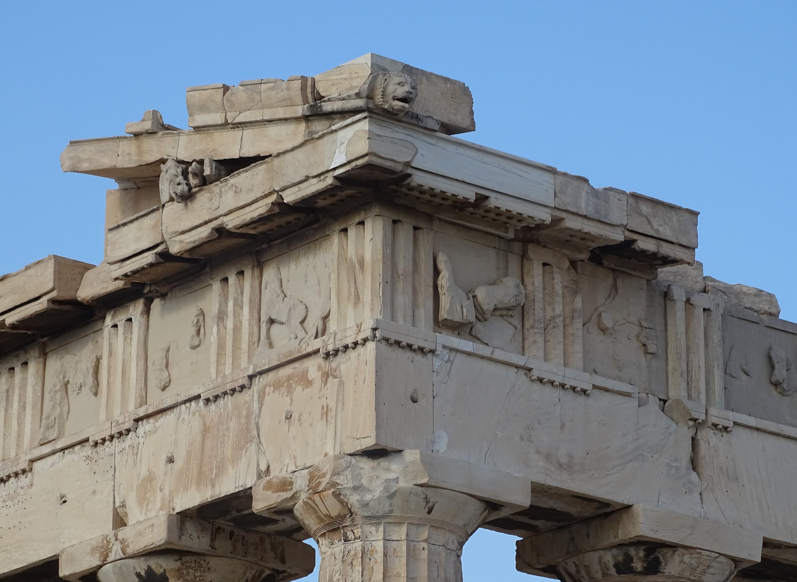 Pale marble sculptures and fragments from a larger group, with damaged or missing sections that reveal their separation from the original architectural setting.