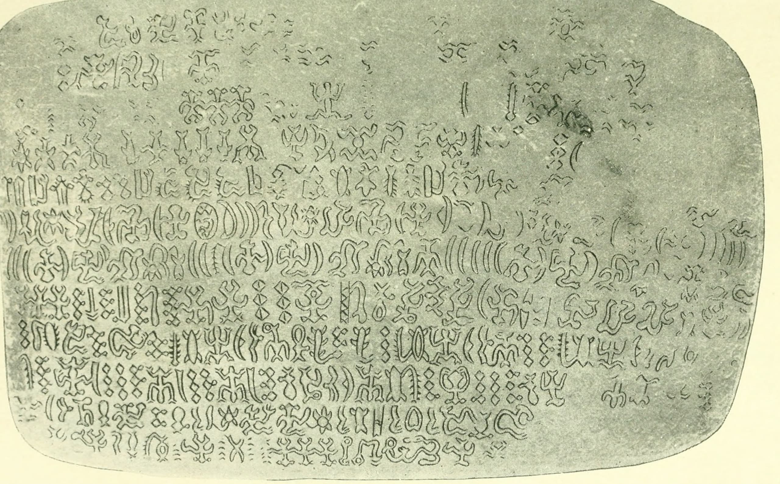 A wooden crescent-shaped pectoral ornament with two pointed ends, carved with two compact glyphs in the rongorongo script.