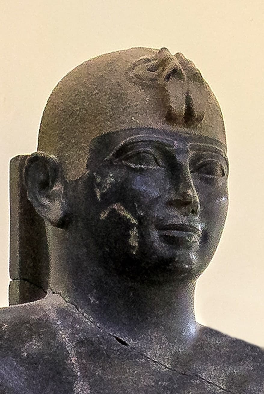 A small standing figure in the form of a mummified body, arms crossed, with hieroglyphic inscription bands running vertically down the front.