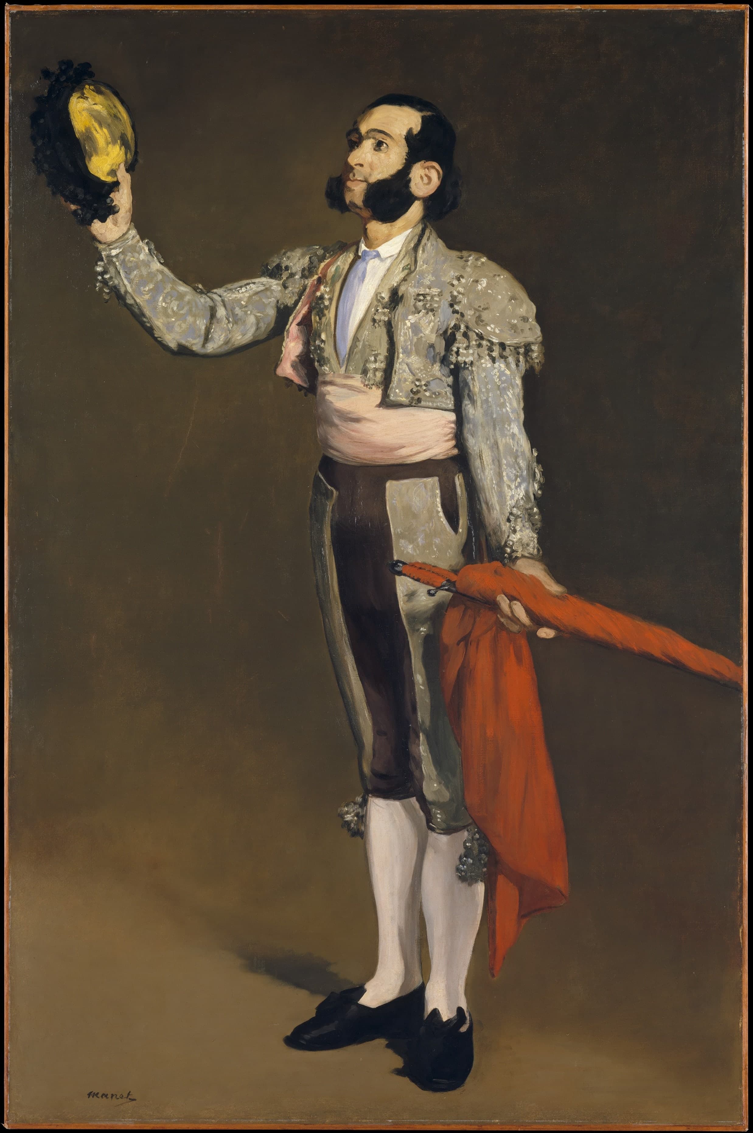 A full-length bullfighter in dark costume stands against a bare, dark ground, one arm raised with a hat in a formal salute.