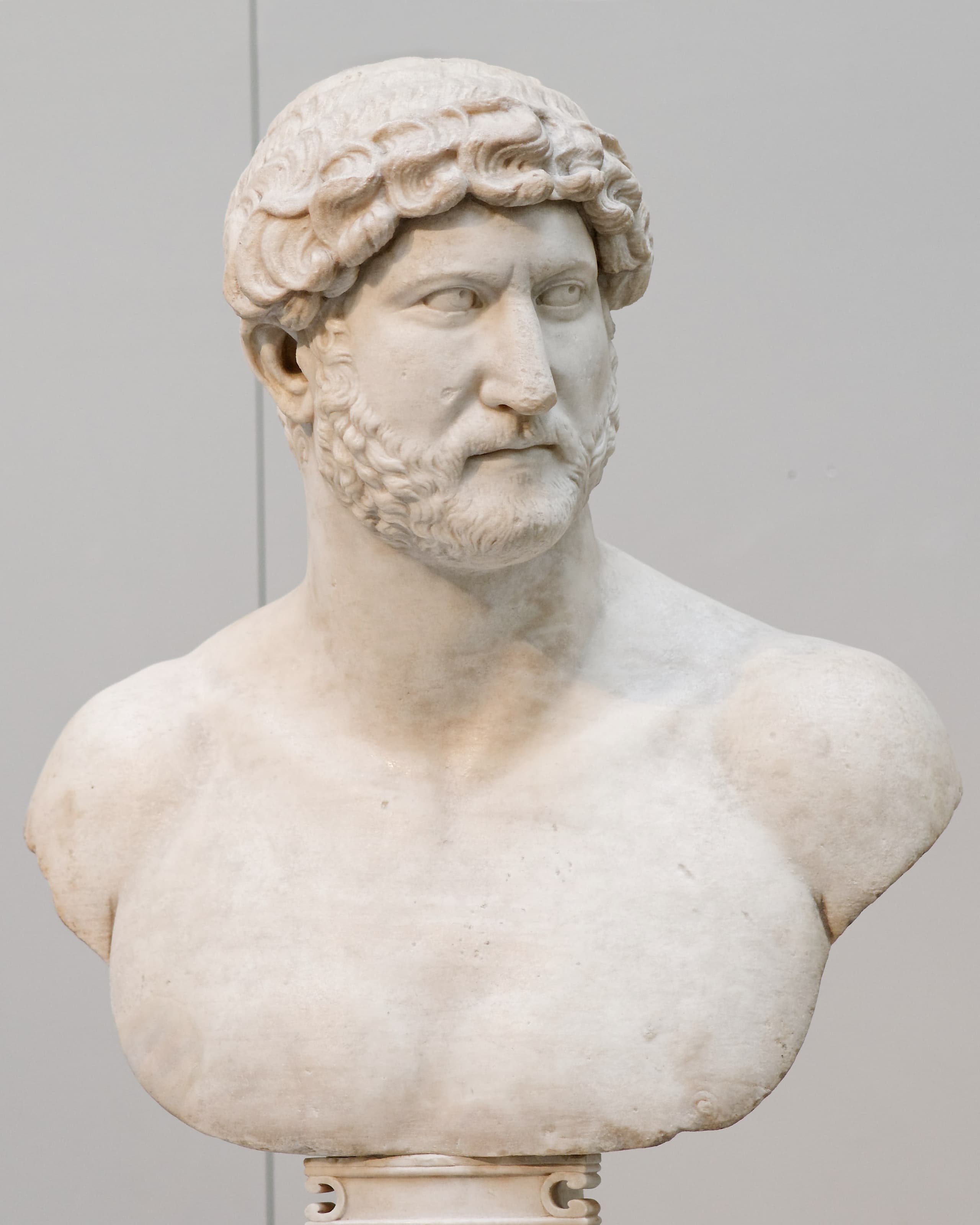 A carved marble bust of a man shown bare-chested, without armour or drapery, the head and upper torso finished in the round and cut off below the chest.