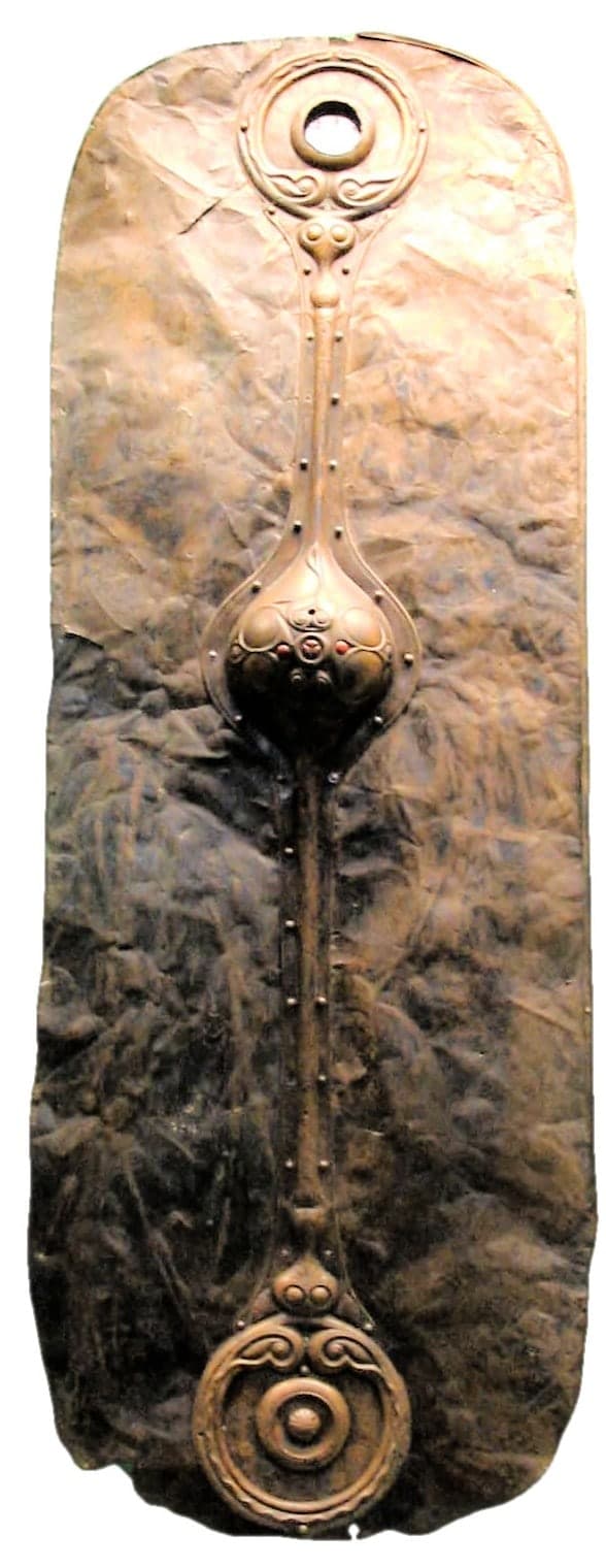 A large, elongated bronze shield facing with a smooth dark metal surface, gently curved, shown as a flat decorative front rather than a thick complete shield.